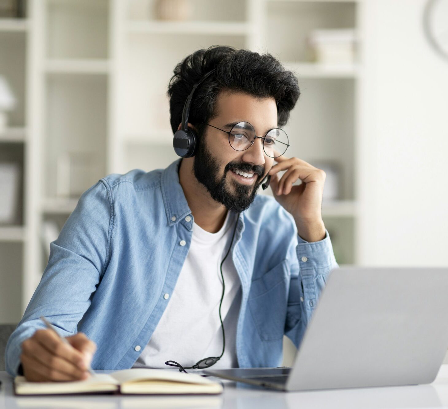 Online Education. Indian Smiling Man In Headset Study With Laptop At Home