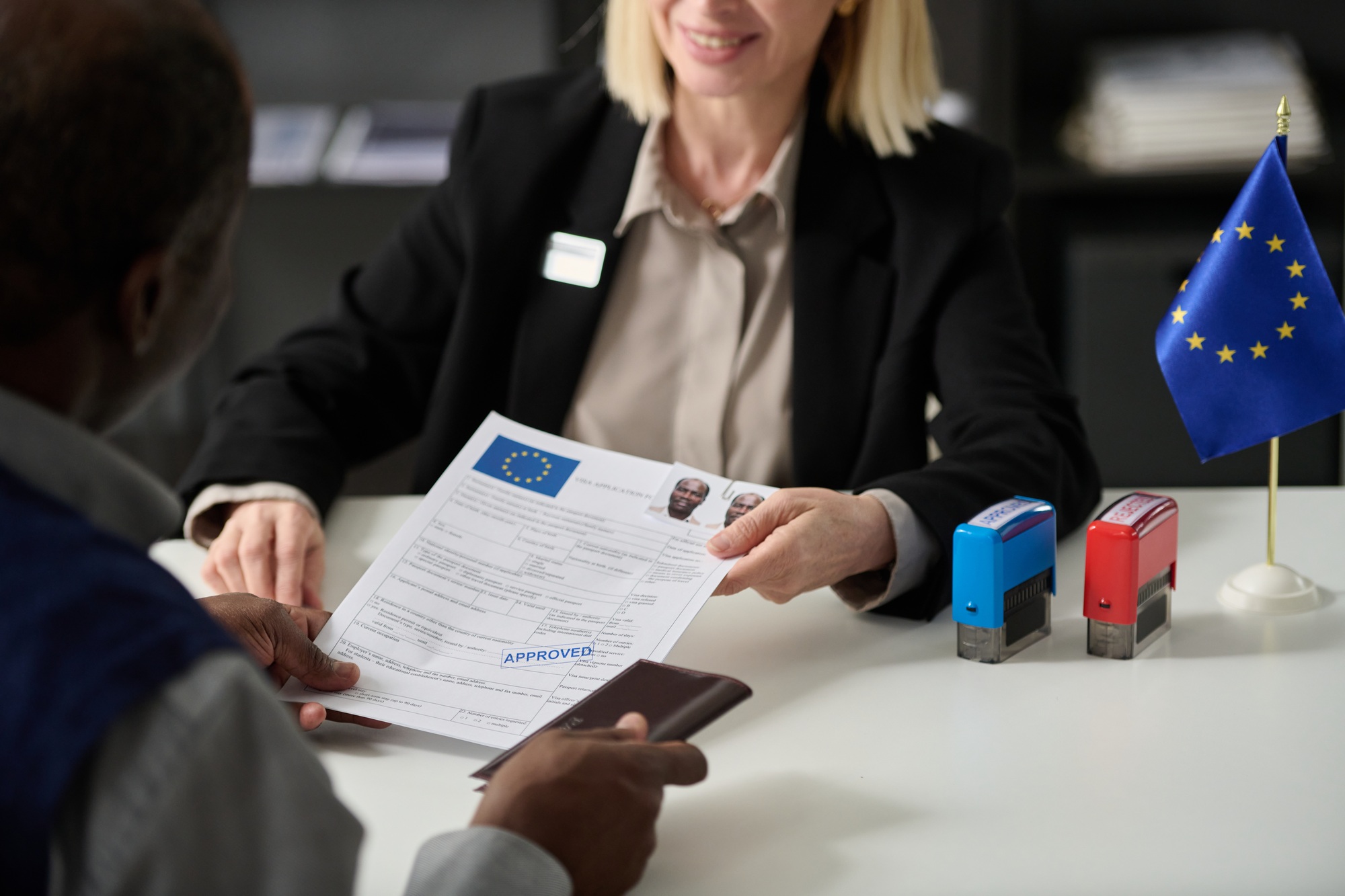 Close up of smiling woman handing approved visa