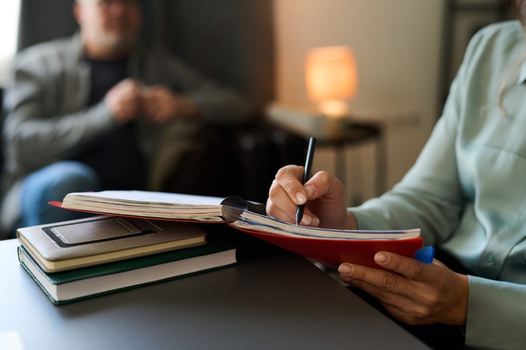 Counseling Session with Notebook and Pen in Hand